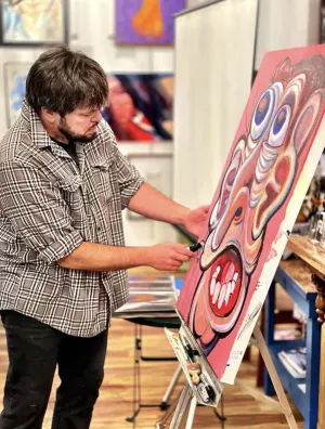 Stow Dunham painting a canvas in the gallery.