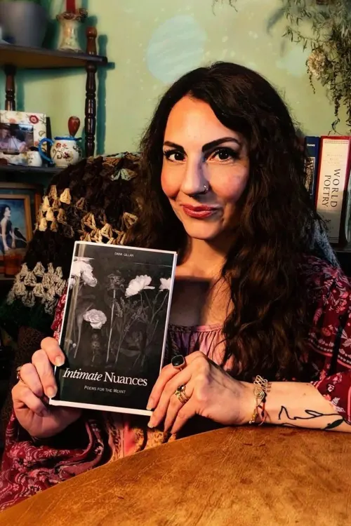 Dana Gillan holding her poetry collection, Intimate Nuances.